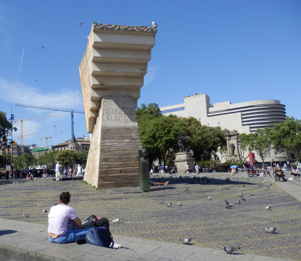 Skulptur Beton abgetreppt gegen den Beschauer im Brunnen, im Vordergrund junger Mann