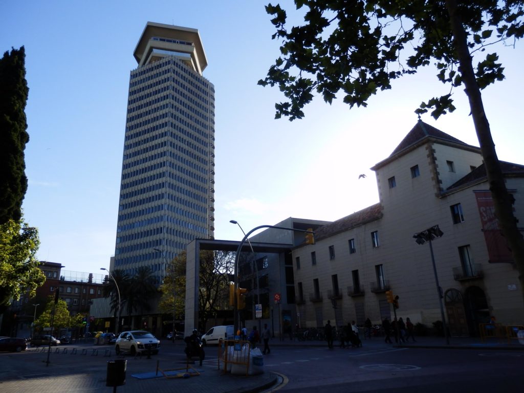 Torre Colon links, Beton-brut-Architektur, Nachbarbebauung traditionell mit weißer Putzfassade rechts