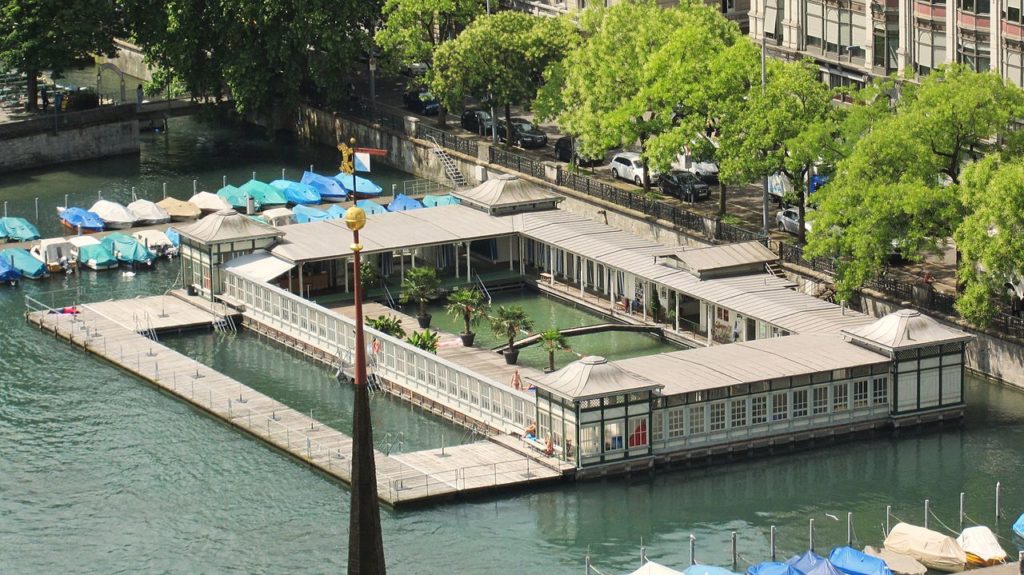 Freibad in der Limmat, rechteckige, gedeckte Umgänge, Aussenwände in kleinteiliger Holz-Glas-Verkleidung